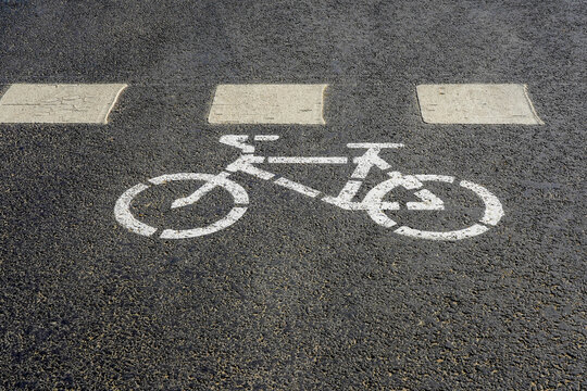 Photo of a bicycle painted with white paint on gray asphalt