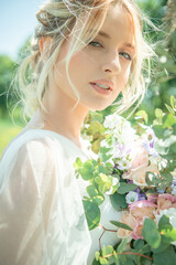 Fototapeta premium Lovely bride, blonde with a luxurious wedding bouquet. Portrait. Shooting in high key.