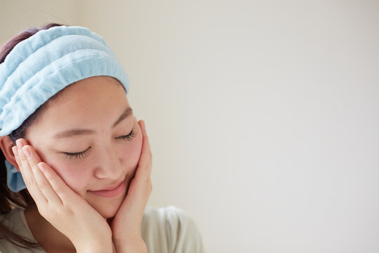 両手をほほのあてている若い女性