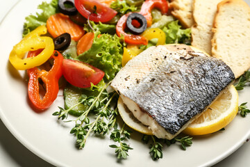 Fototapeta na wymiar Plate of tasty sea bass fish with vegetables on table