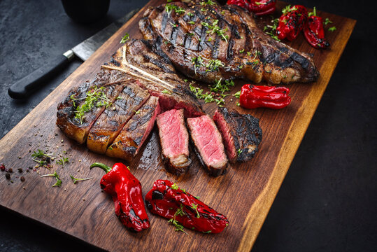 Rustic traditional barbecue dry aged wagyu t-bone and cote de boeuf beef steak with paprika and chili served as to view on a wooden design board