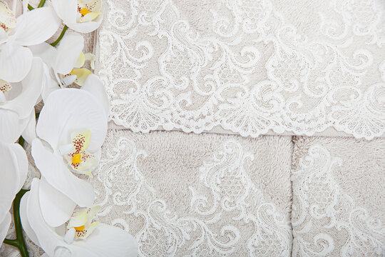 Beige towel with snow-white lace and orchid branch,. © malinaphoto