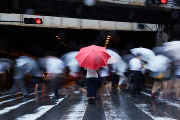 歩道で傘を持ってたたずむ女性