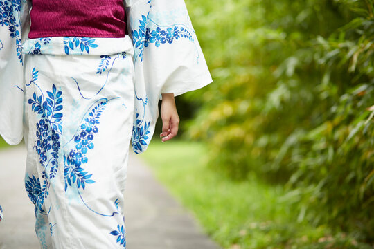 日本庭園を歩く浴衣の女性
