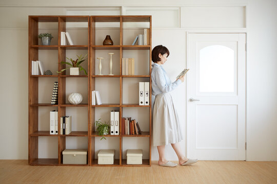 棚の横で本を読む女の人