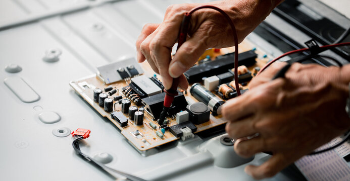 Close up of Technician measuring voltage electronic circuit board television, Service after sale fix electric equipment within insurance.