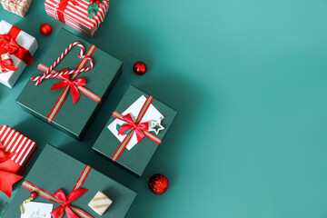 Christmas gift boxes with candy canes and balls on green background