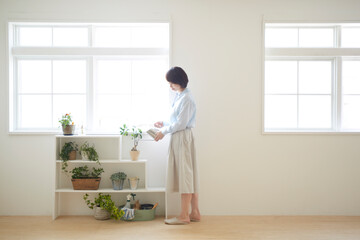 室内植物に水をあげている女の人