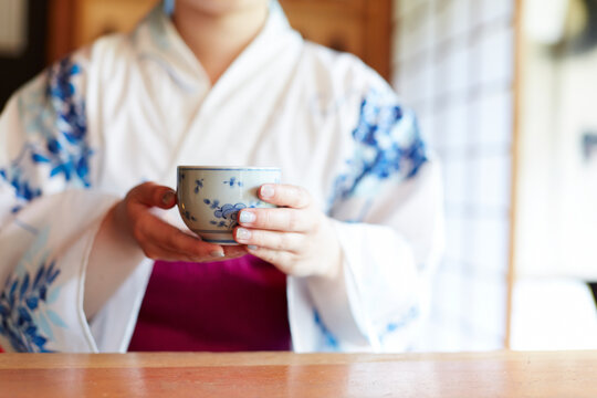 お茶を飲む浴衣の女性の手元