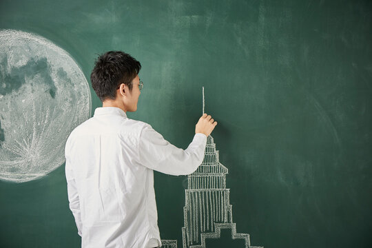 満月が描かれた黒板にタワーのイラストを描く