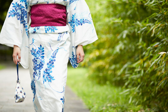 日本庭園を歩く浴衣の女性