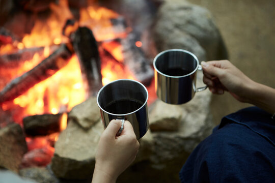 焚き火を囲ってコーヒーを飲む二人