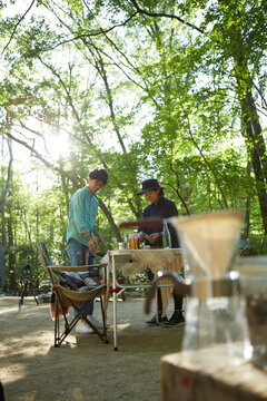 キャンプ場でテーブルセッティングをしているカップル