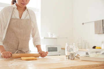 麺棒で生地を伸ばす女性