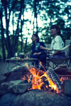 たき火のそばでコーヒーを淹れている二人