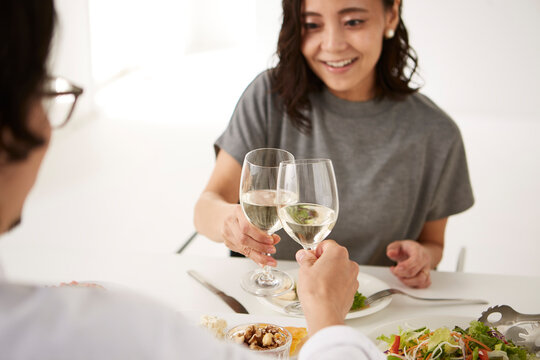 白いダイニングテーブルで食事する男女