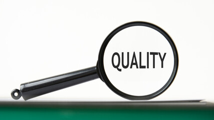 Magnifying glass with text quality on notebook