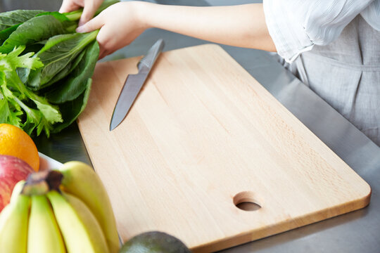 野菜を切ろうとしている女性の手元