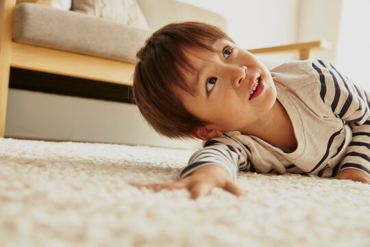 白いラグに寝転んでいる男の子