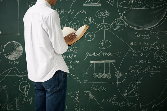 黒板の前で本を読む