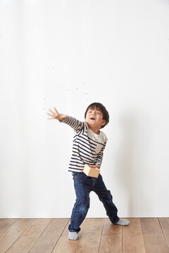 部屋の中で豆まきをする男の子