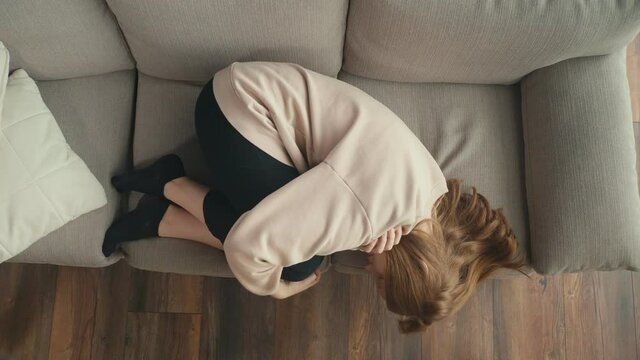 View From Above. A Pensive Red-haired Girl is Sad Alone at Home. A Depressed Teenager Suffers From Loneliness, Lack of Communication, Lack of Friends. Mental Health.