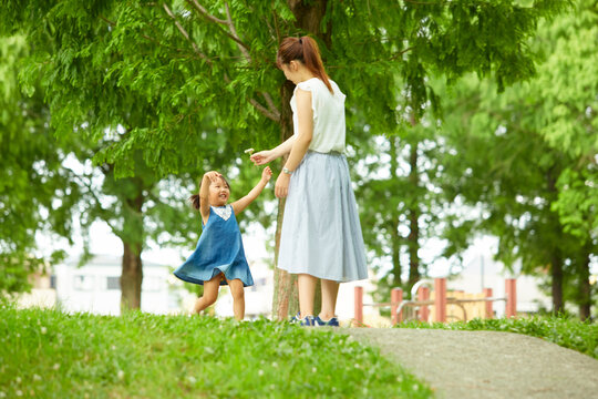 公園内で女の子に花を渡すお母さん