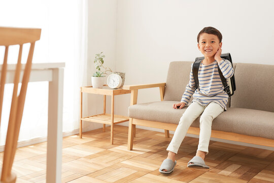 ソファに座るランドセルを背負った男の子