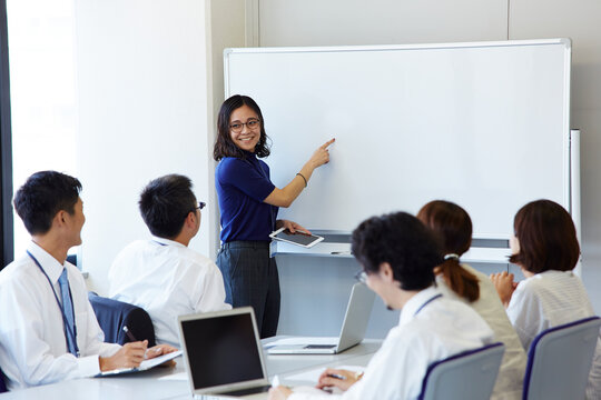 プレゼンをしている女性と話し合う社員