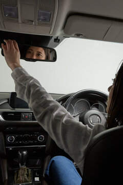 バックミラーを確認する運転席の女性