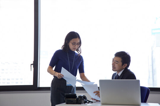 書類を見ながら話す男性と女性