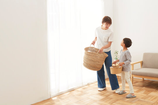 洗濯物が入ったカゴを運ぶ親子