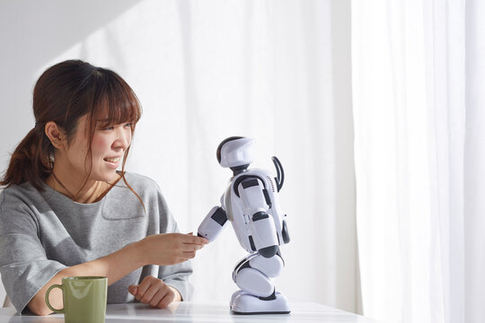 ロボットと握手をする女性