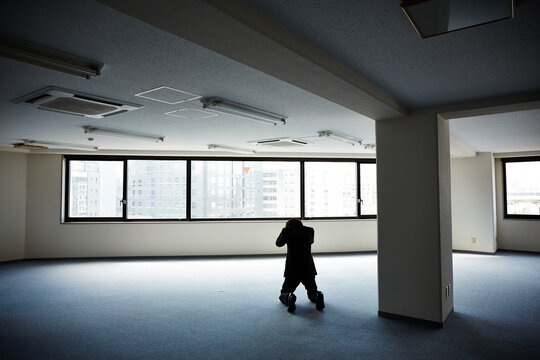 何もないオフィスで膝をつき頭を抱える男性