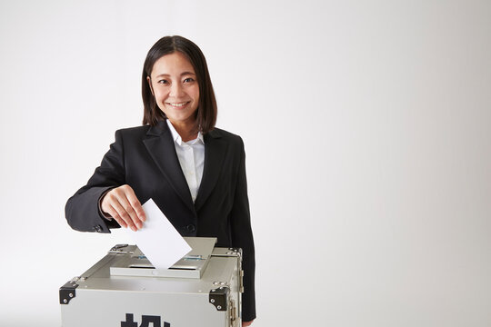投票をしているスーツを着た女性