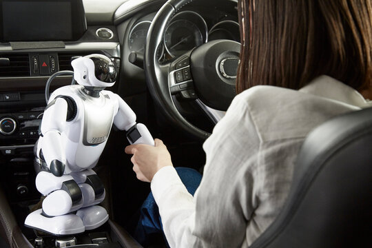 ロボットを使って自動運転車を操作する女性