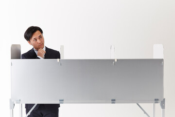 投票記載台を使用しているスーツを着た男性