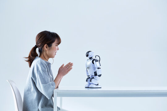 ミニロボットとおしゃべりする女性