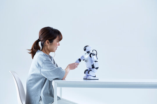 ミニロボットとおしゃべりする女性