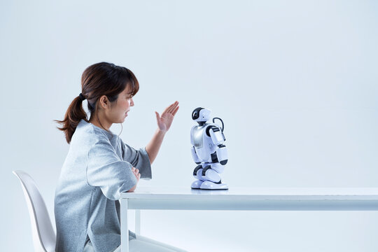 ミニロボットとおしゃべりする女性