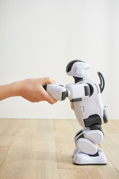 女性に手を握られているロボット