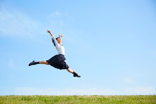 河川敷でジャンプする女子高生