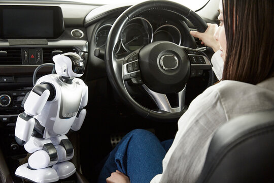 ロボットを使って自動運転車を操作する女性