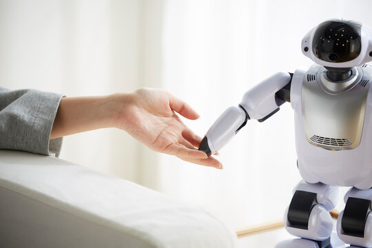 ロボットの手に触れる女性