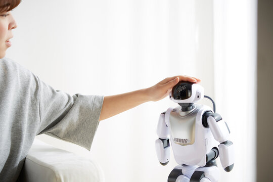 ロボットの頭を撫でる女性