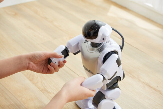 女性に手を握られているロボット