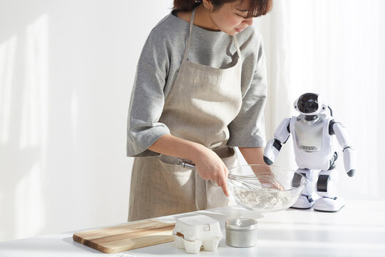 ロボットとお菓子作りをしている女性