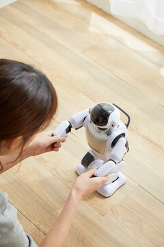 女性に手を握られているロボット