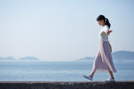 堤防の上を歩く女性 ,日本,和歌山県,和歌山市,加太周辺
