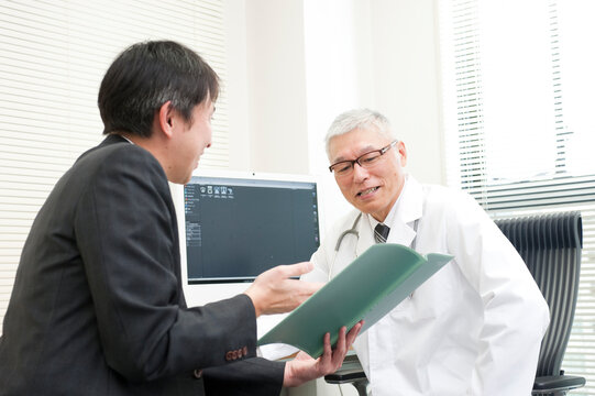 診察室で情報提供するＭＲと白衣を着た医師